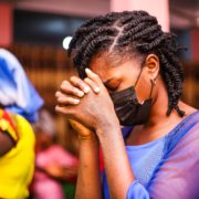 A black woman praying in a church